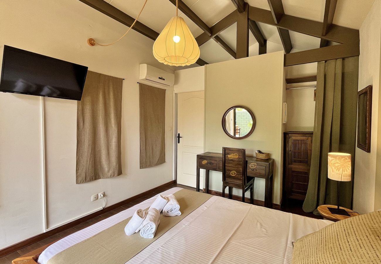 Schlafzimmer im Nebengebäude mit Fernseher und Holzmöbeln Villa des Parfums