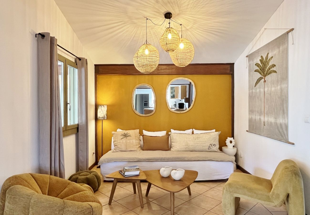 Living room with sofa, ochre wall and mirrors Villa des Parfums La Saline-les-Bains