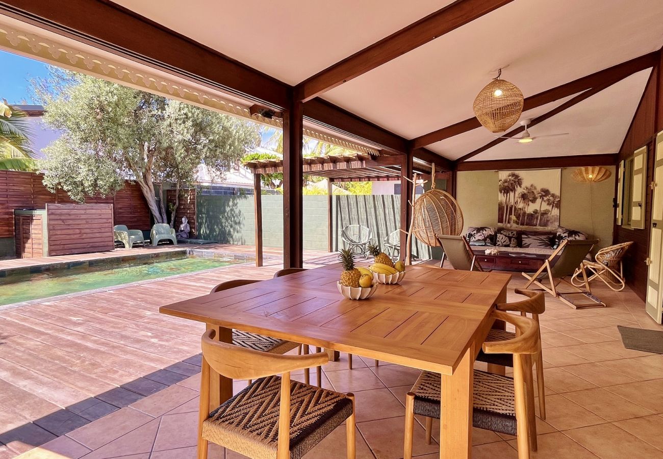 Covered terrace with dining table and swimming pool Villa des Parfums La Saline