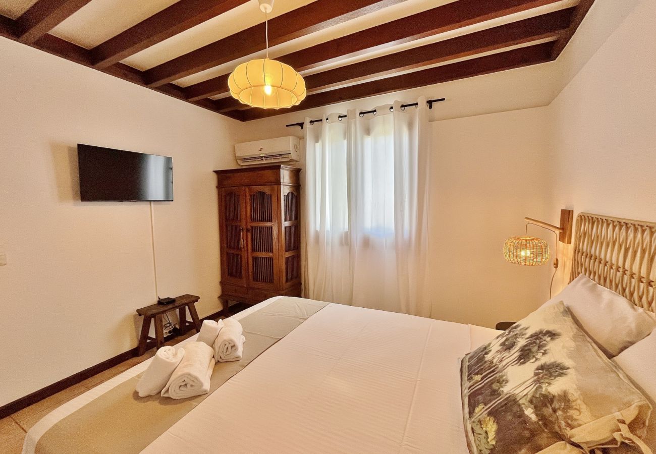 Double bedroom with wall-mounted TV Villa des Parfums La Saline