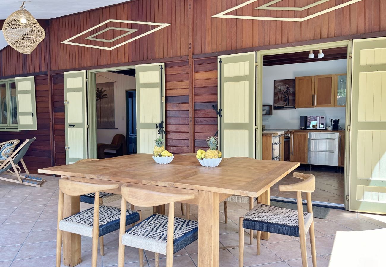 Grande table à manger en bois sur la terrasse de la Villa des Parfums