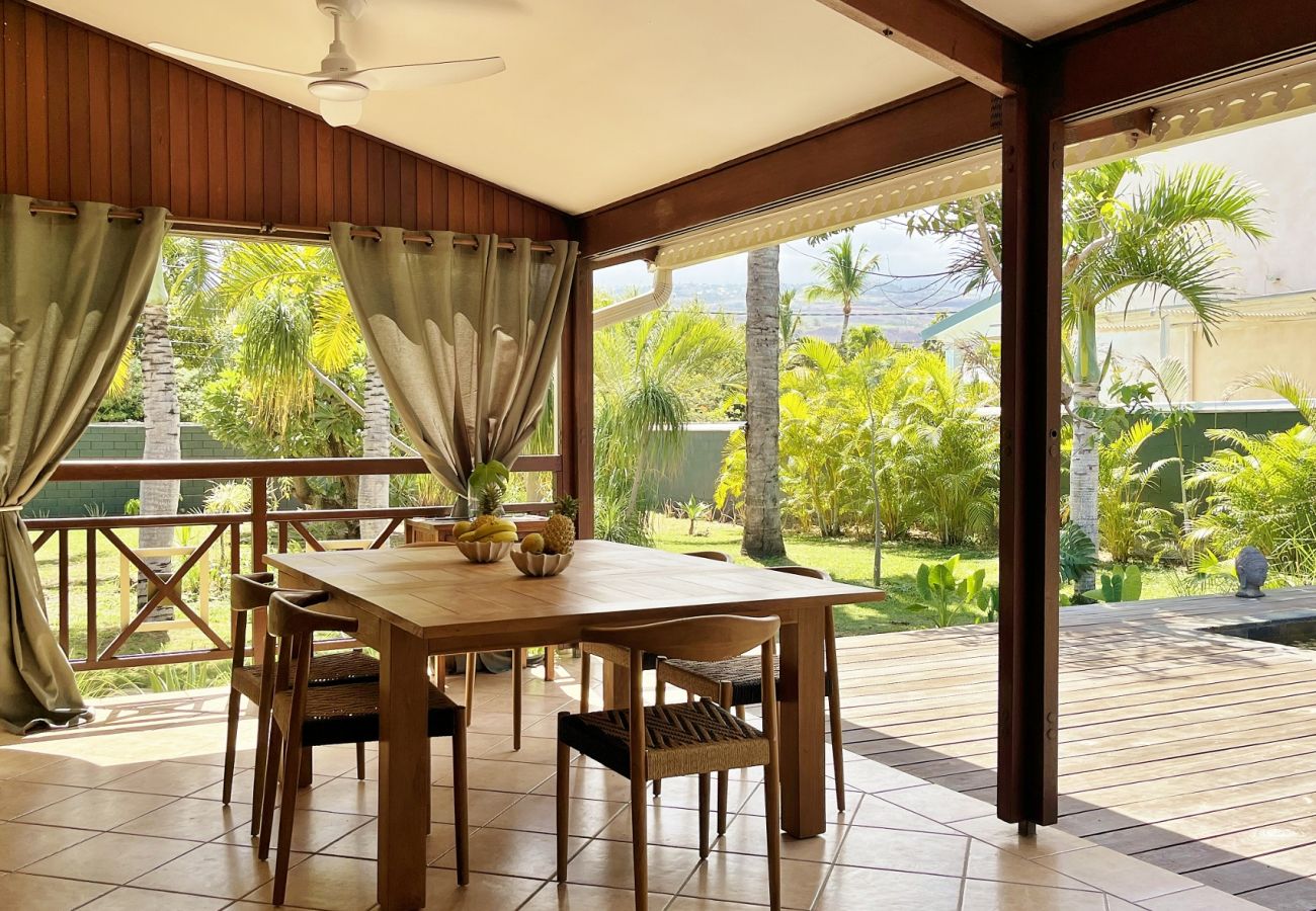 Varangue couverte avec table à manger et vue jardin Villa des Parfums